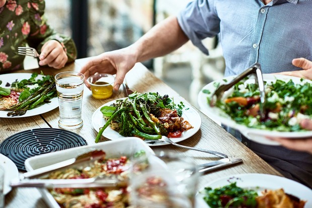© Getty Images Des gens autour d'une table mangeant des aliments sains © Getty Images
