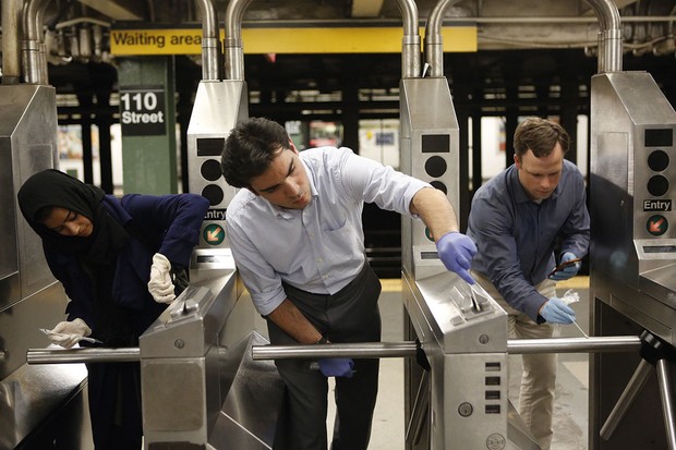 Le professeur Christopher Mason et des bénévoles collectent des échantillons bactériens sur les tourniquets du métro pour vérifier une partie de la vie microbienne trouvée dans nos villes © Getty Images Le professeur Christopher Mason et ses collègues tamponnant les barrières de billets dans une station de métro © Getty Images