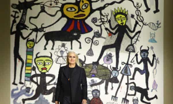 La créatrice Dior Maria Grazia Chiuri sur le podium devant une tapisserie inspirée de l'œuvre de l'artiste indien Madhvi Parekh.