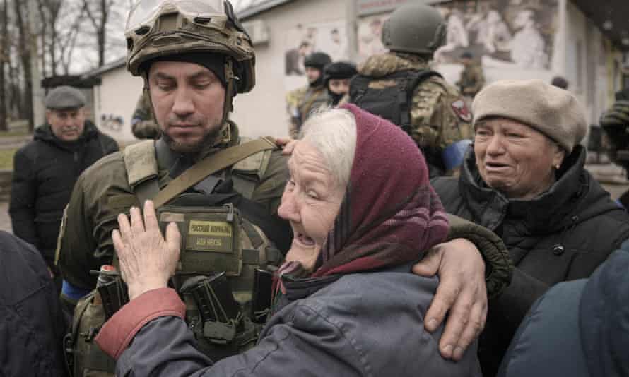Les dirigeants de l'UE condamnent le meurtre de civils non armés à Bucha et à Kiev | Ukraine 1 Une femme embrasse un militaire ukrainien après l'arrivée d'un convoi de véhicules militaires et d'aide dans la banlieue de Bucha, anciennement occupée par la Russie.