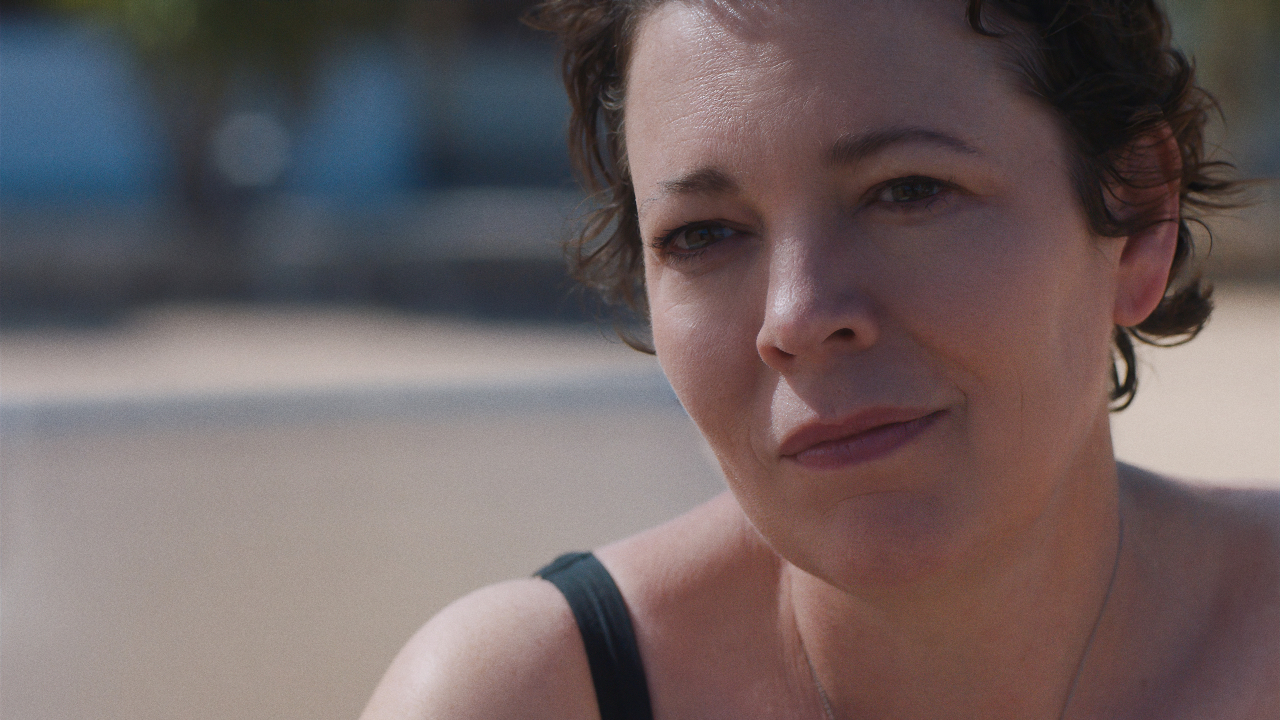 Olivia Colman souriante dans La fille perdue.