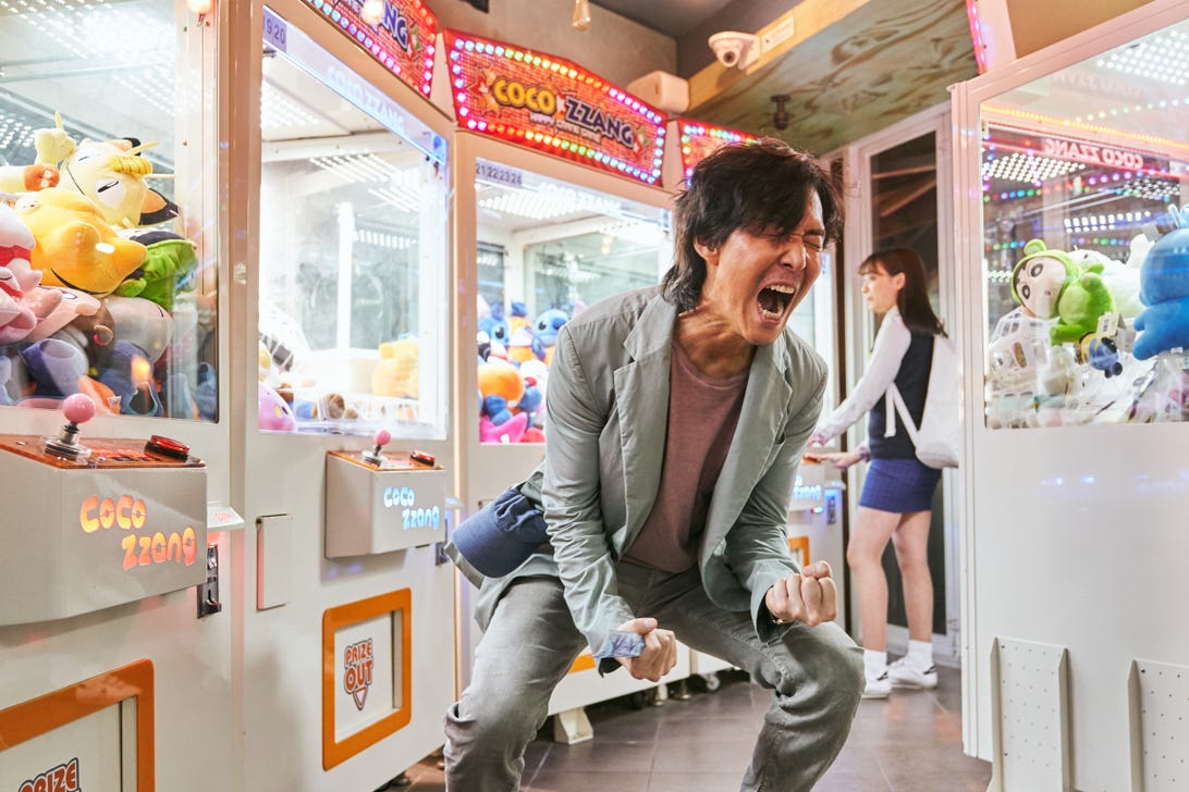 'Stranger Things' Sera le plus gros succès de Netflix à ce jour. Comment? Netflix a changé ses règles 5 Le personnage Seong Gi-hun hurle avec les poings fermés dans une arcade colorée et très éclairée.