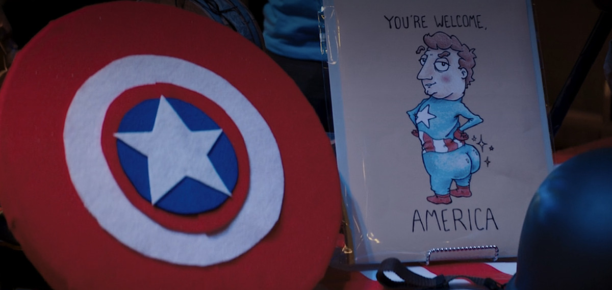 Une capture d'écran d'un épisode de Mme Marvel, montrant une carte de dessin animé avec Captain America affichant un gros cul de bulle à la caméra, avec les mots « De rien, Amérique »