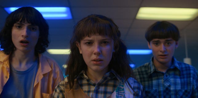 'Stranger Things' Sera le plus gros succès de Netflix à ce jour. Comment? Netflix a changé ses règles 3 Mike, Eleven et Will regardent confusément la caméra dans Stranger Things saison 4