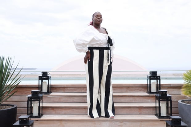 Déborah Lukumuena : 'Être à l'écran avec le corps et la peau que j'ai, c'est déjà très politique' | Film 1 Lukumuena en pantalon large rayé noir et blanc et haut blanc à Cannes en mai dernier.