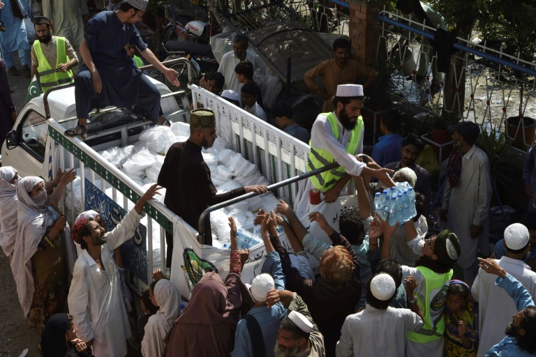De l'eau potable est distribuée aux personnes déplacées par les inondations dans un camp à Nowshera, au Pakistan (AFP/Archive - Abdul MAJID)