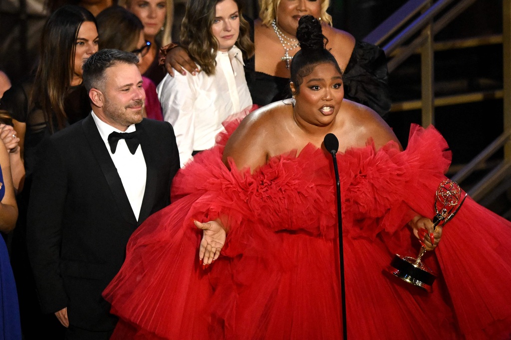 'Squid Game,' 'Abbott Elementary' gagne gros aux Emmys 2022 5 Lizzo recevant son prix Emmy. Elle porte une robe rouge vif et parle dans le micro et tient son Emmy dans sa main gauche.