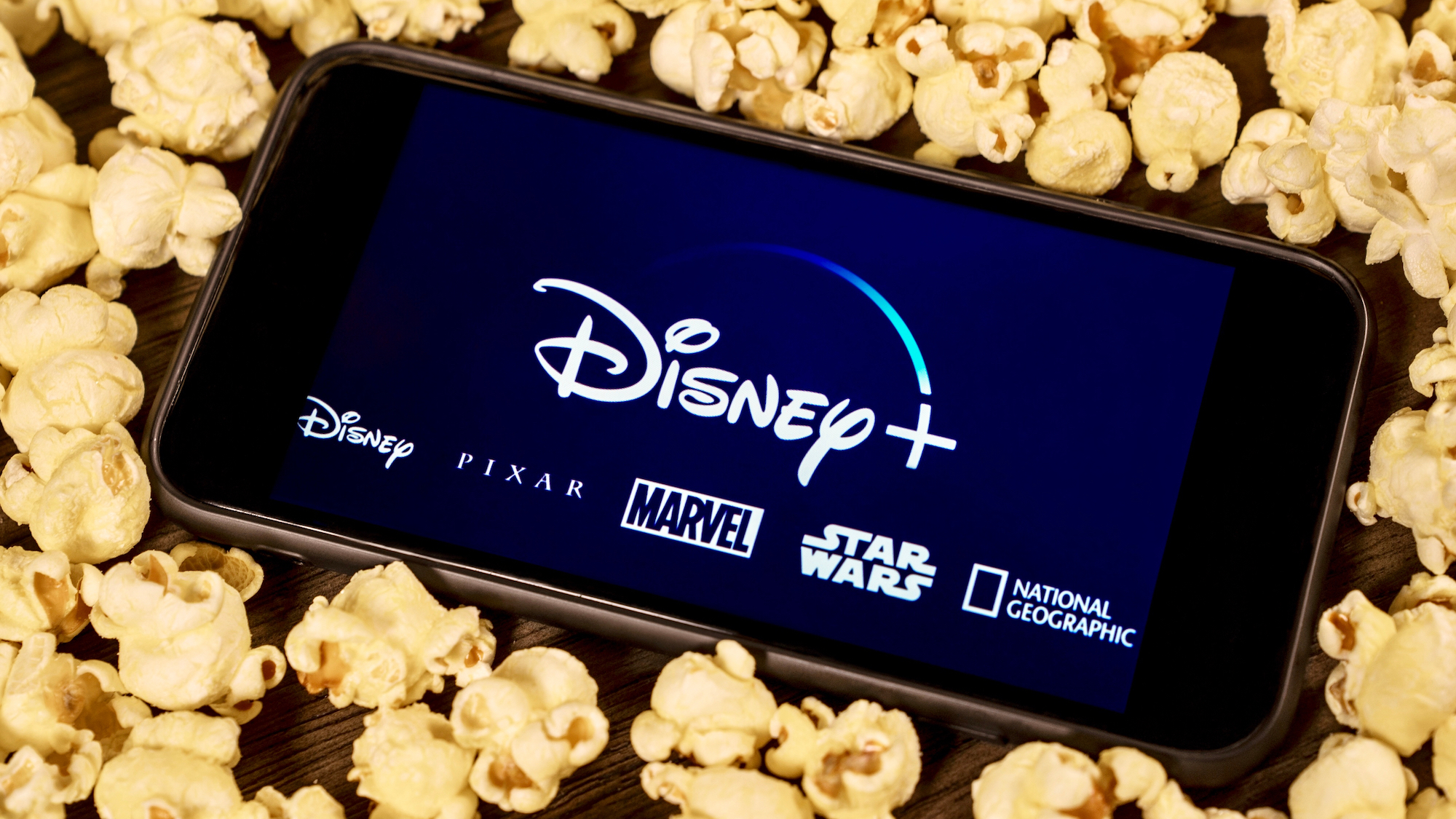 Blog en direct Disney Plus Day 2022 – toutes les grandes nouvelles au fur et à mesure 3 Le logo Disney Plus sur un téléphone entouré de pop-corn
