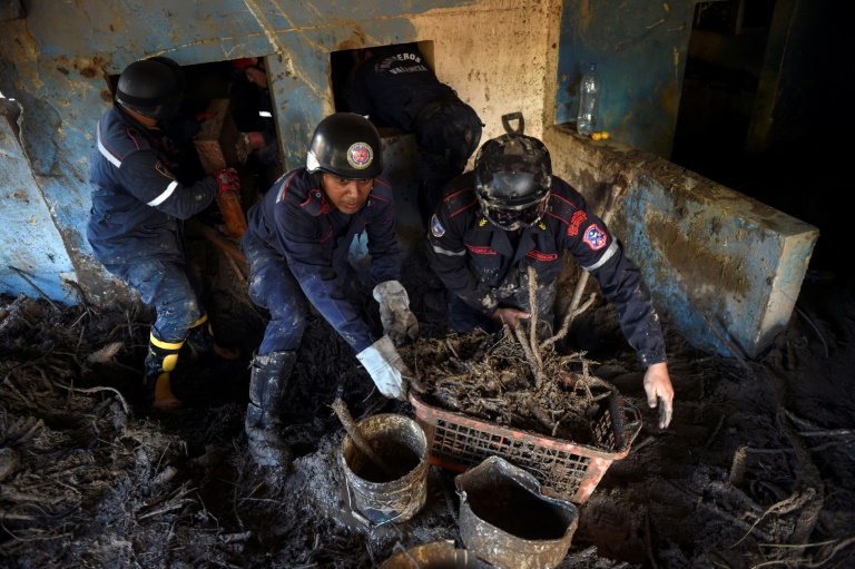Les pompiers fouillent la maison de la mère de Natalie Matos, qui a disparu après qu'un glissement de terrain a frappé Las Teherias.  (AFP - Miguel ZAMBRANO)