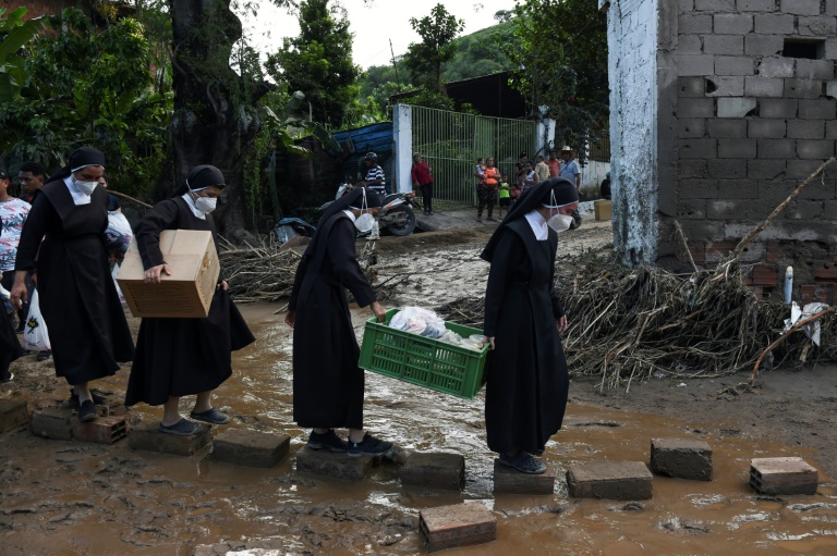 Des nonnes transportent des colis d'aide humanitaire à Las Teherias.  (AFP - Miguel ZAMBRANO)