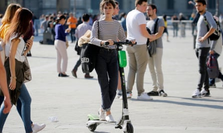 "Jungle" piétonne : la dispute à Paris sur les scooters électriques de location | Paris 3 Une femme conduit un scooter électrique de la société de services de partage de vélos Lime à travers Paris.