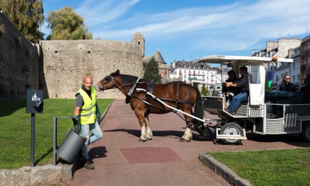 "Un calme doux": les rues de France résonnent à nouveau au son des chevaux au travail | France 1 Julien ramasse un déchet dans une poubelle publique lors d'une collecte hippomobile à Hennebont.