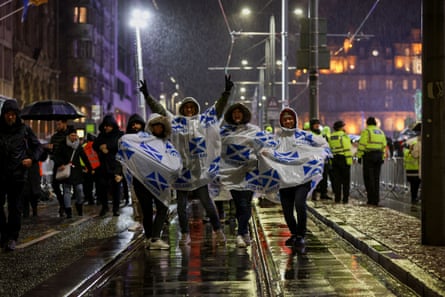 Célébrations du Nouvel An : feux d'artifice et festivités dans les incertitudes mondiales | Nouvelles du monde 2 Les gens attendent sous la pluie avant les célébrations du Nouvel An à Édimbourg.