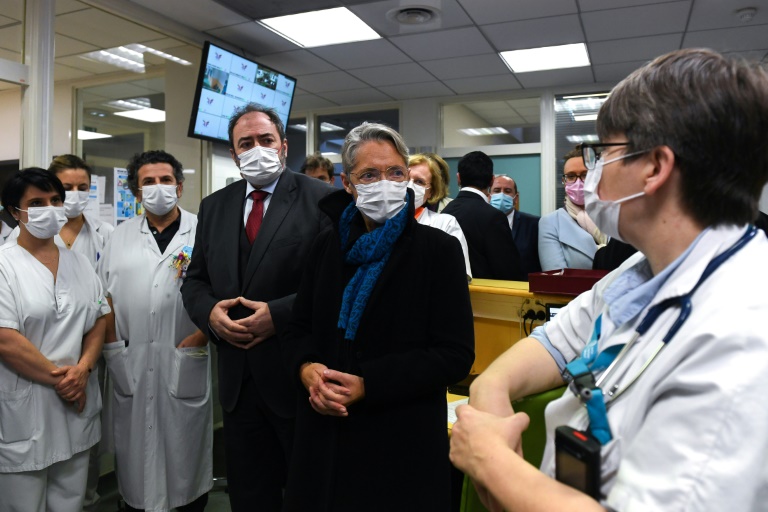 La Première ministre Elisabeth Born (CD) et le ministre de la Santé François Braun (CG) discutent avec le personnel médical le 31 décembre 2022 aux urgences pédiatriques d'Argenteuil (POOL/AFP - Anna KURT)