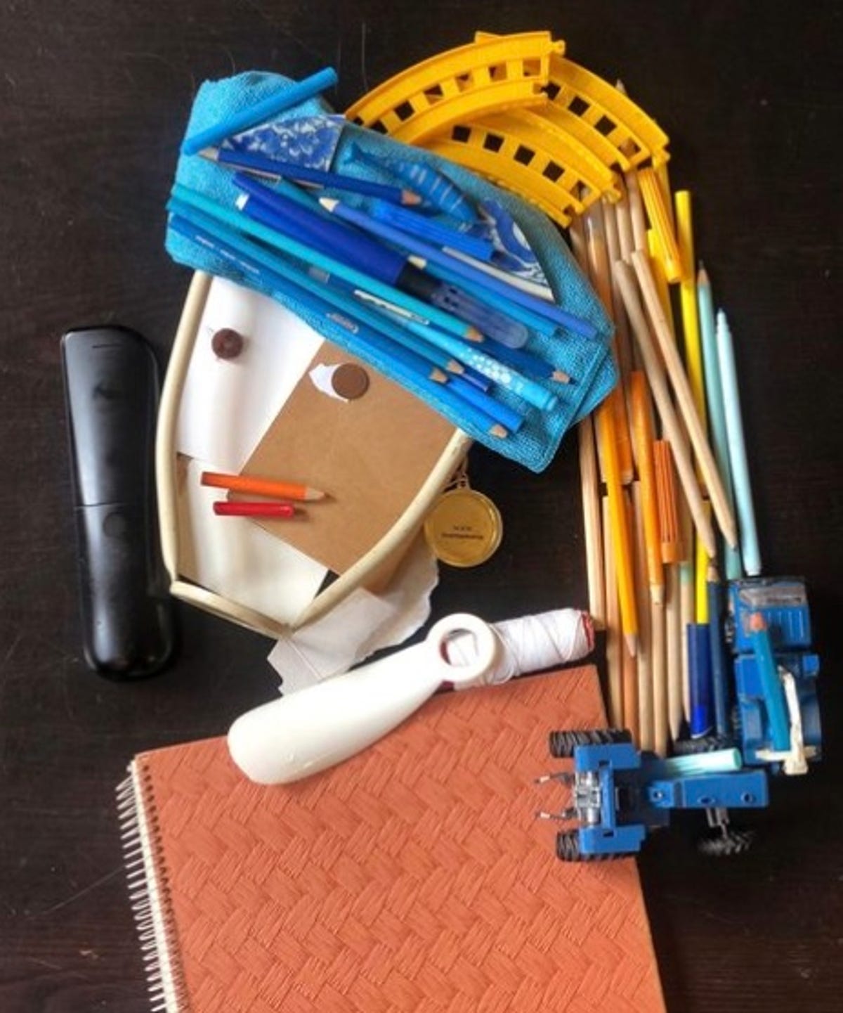 Crayons et autres fournitures scolaires en forme de fille avec une boucle d'oreille en perle