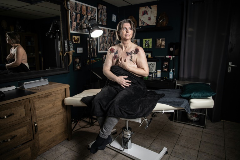 Jacqueline van Schaik se fait tatouer une fleur sur la poitrine après avoir subi une mastectomie suite à un cancer du sein à Lelystad, aux Pays-Bas, le 10 janvier 2023. (AFP - Simon WOHLFAHRT)