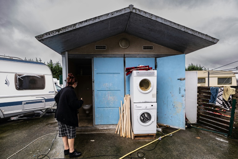 Un membre de la communauté des voyageurs vérifie les toilettes publiques à l'extérieur des camping-cars à Ronchin, dans le nord de la France, le 16 janvier 2023. (AFP - Sameer Al-DOUMI)