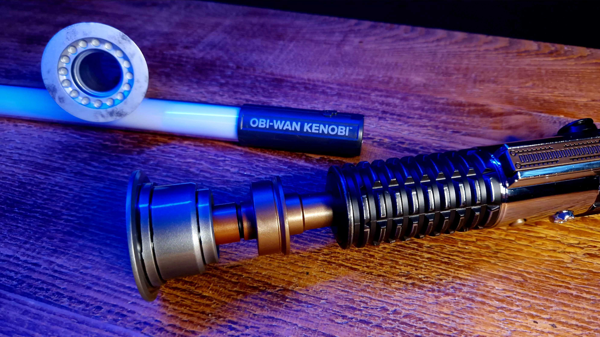 Star Wars The Black Series Obi-Wan Kenobi Force FX Elite manche de sabre laser, émetteur d'affichage, émetteur d'action et lame sur une table en bois