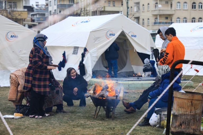Des sans-abri se réchauffent près d'un feu dans un camp du parc Masal, le 10 février 2023 à Gaziantep, en Turquie (AFP - Zein Al RIFAI)