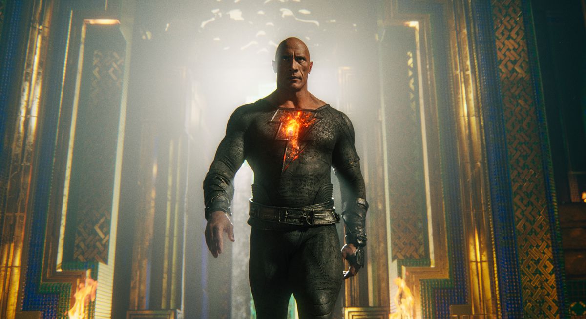 Dwayne Johnson s'avance vers la caméra dans un costume noir moulant avec un éclair lumineux sur la poitrine dans le rôle du personnage principal de Black Adam.