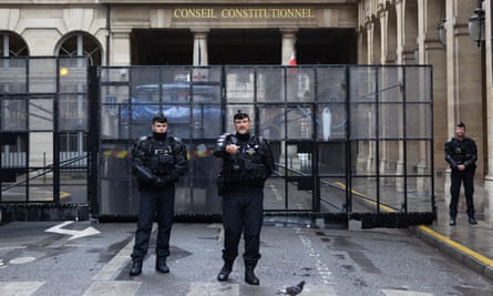 La justice française approuve le plan impopulaire de Macron visant à relever l'âge de la retraite | France 1 La police monte la garde à côté d'une barrière à l'extérieur du bâtiment du conseil constitutionnel vendredi.