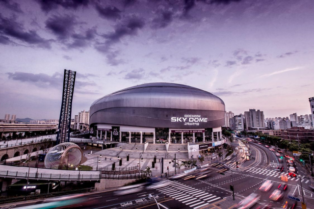 LoL Worlds 2023 : dates, lieu, billets et plus 3 Le Gocheok Sky Dome à Séoul, en Corée du Sud. Un stade en forme de dôme avec un grand mât devant une route à plusieurs voies, avec la ville en arrière-plan.