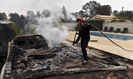 Incendie dévastateur embrase un camping et 500 hectares dans le sud de la France 1 Un pompier éteint un incendie à côté d'une piscine