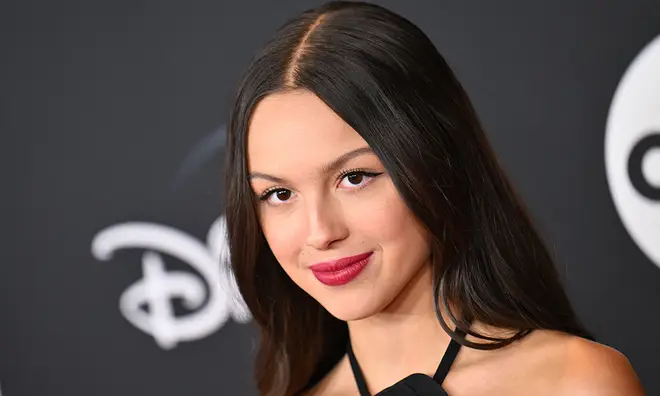 Chaque chanson de la set list de la tournée Guts d'Olivia Rodrigo 4 Olivia Rodrigo portant une robe noire sur le tapis rouge Disney avec du rouge à lèvres rouge